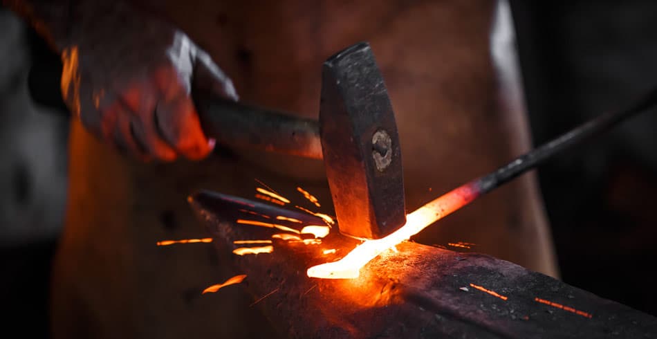 Blacksmith forging iron, symbolic of the way sales consulting can refine a company