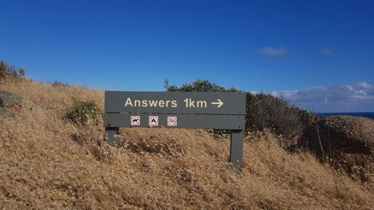 state park directional sign saying answers 1 km asking questions