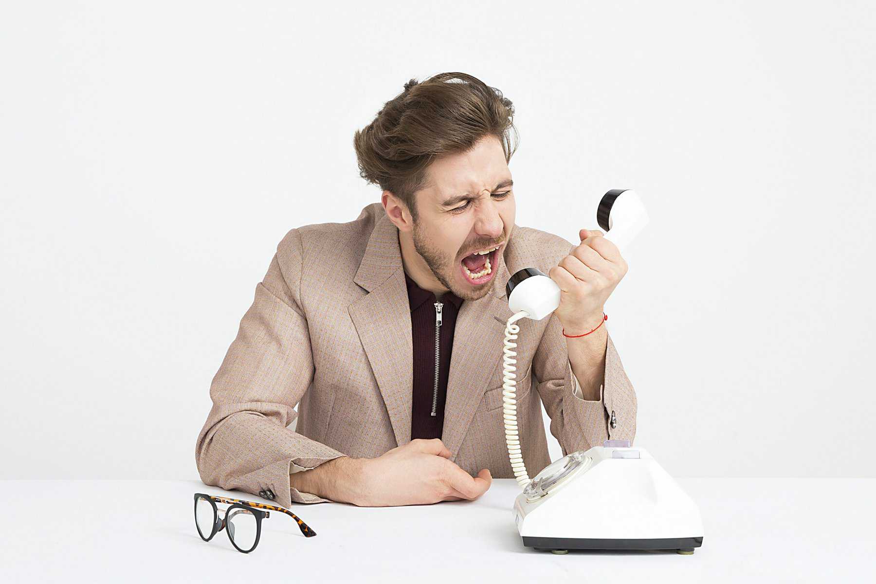 salesman yelling into a white corded phone