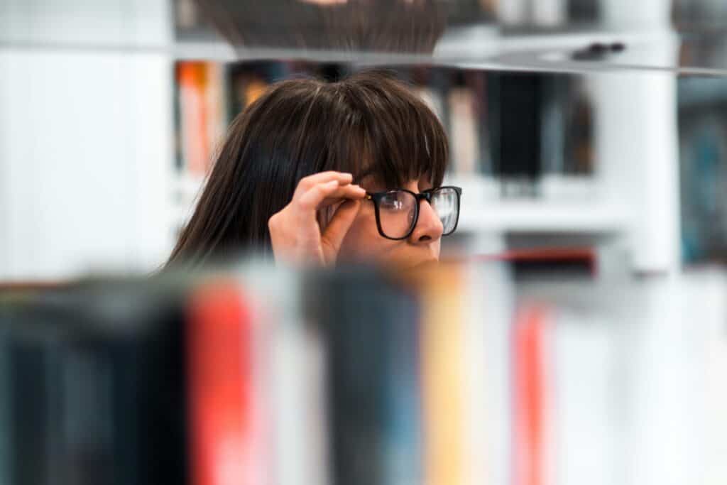 woman with black rimmed glasses looking for sales training