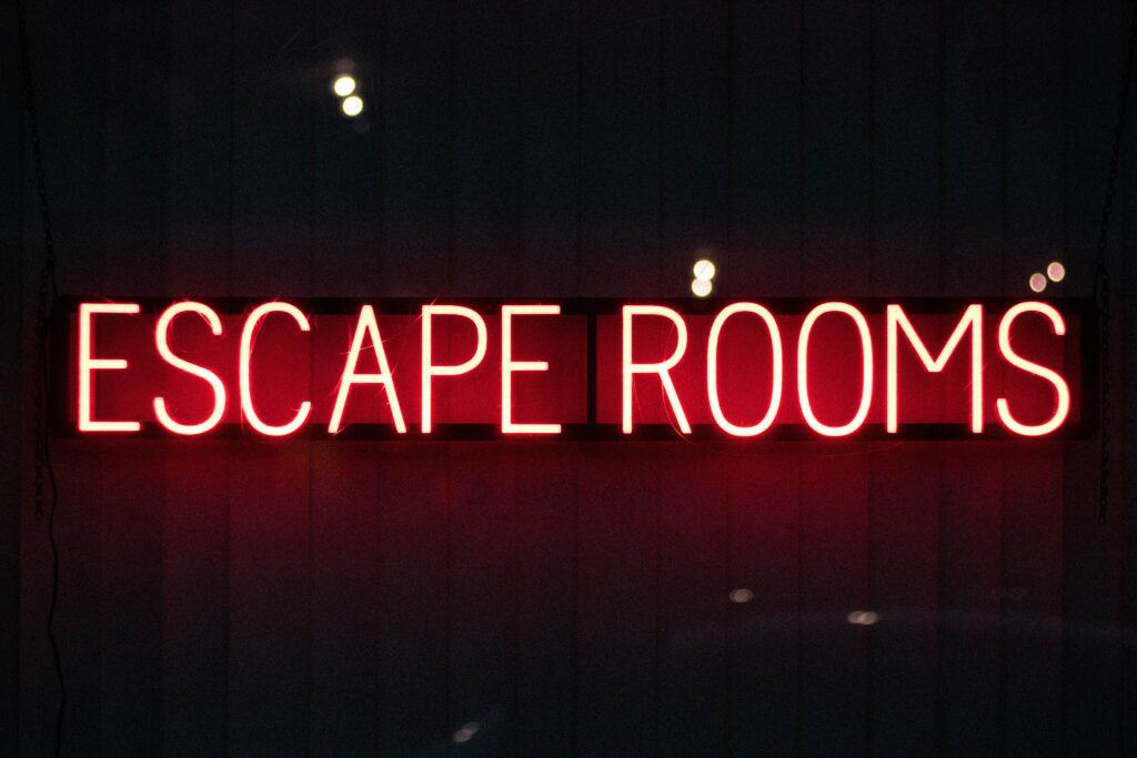 red neon lights reading escape room in black room as one sales leader tactics