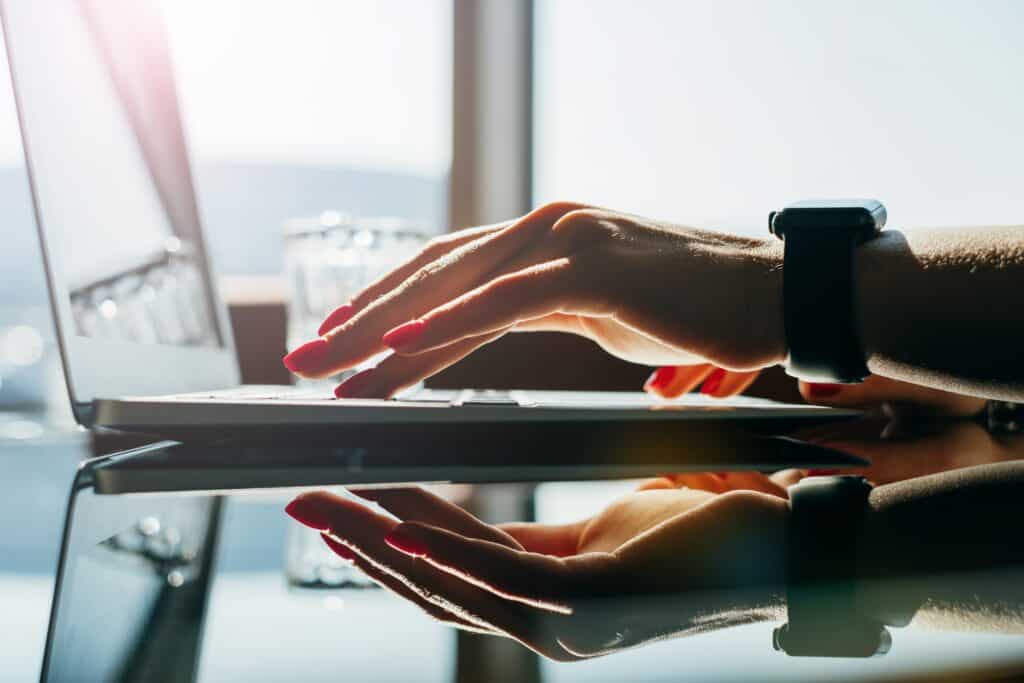 woman at mirrored desk with laptop using one of the prospecting strategies of commenting on social media