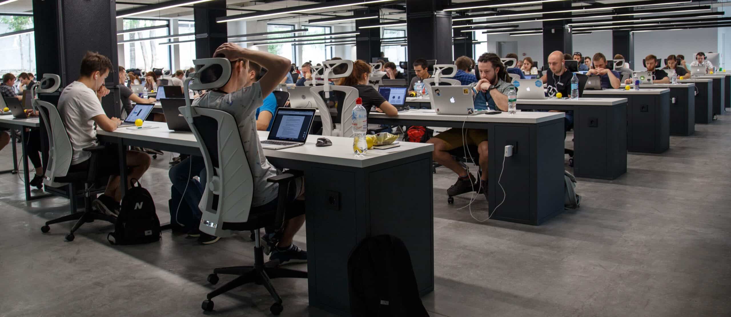 open floor with many desks with workers on computers
