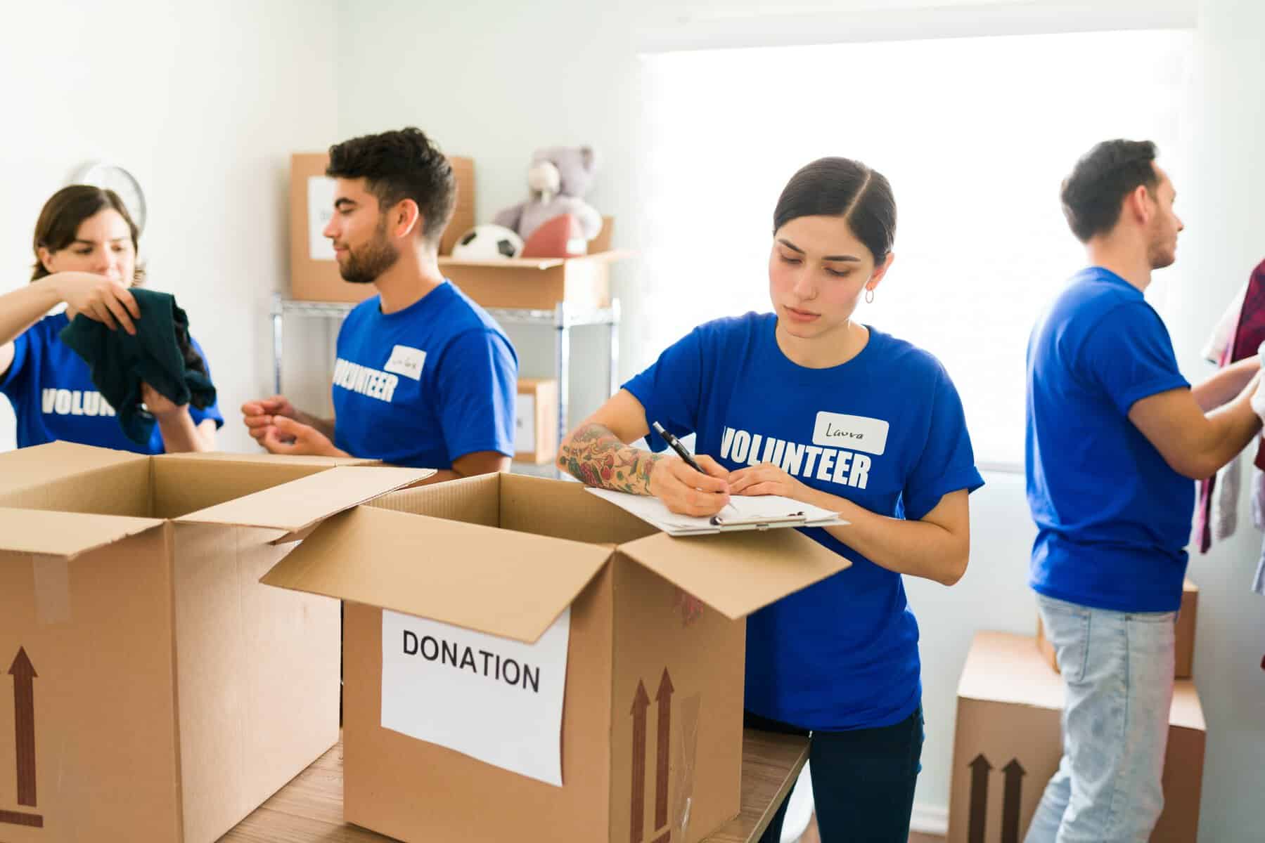 non profit volunteers in blue shirts packing boxes