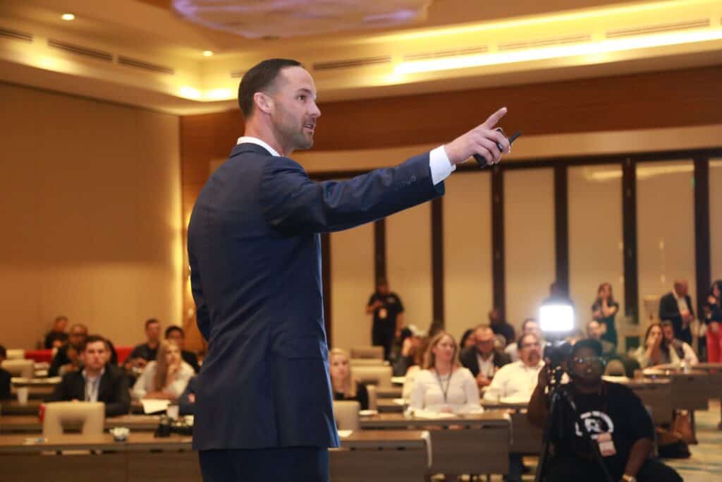 presenter pointing a screen trends in sales with blurred out auditorium  audience.