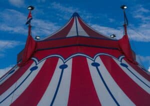 close up of red circus tent with white and blue stripes