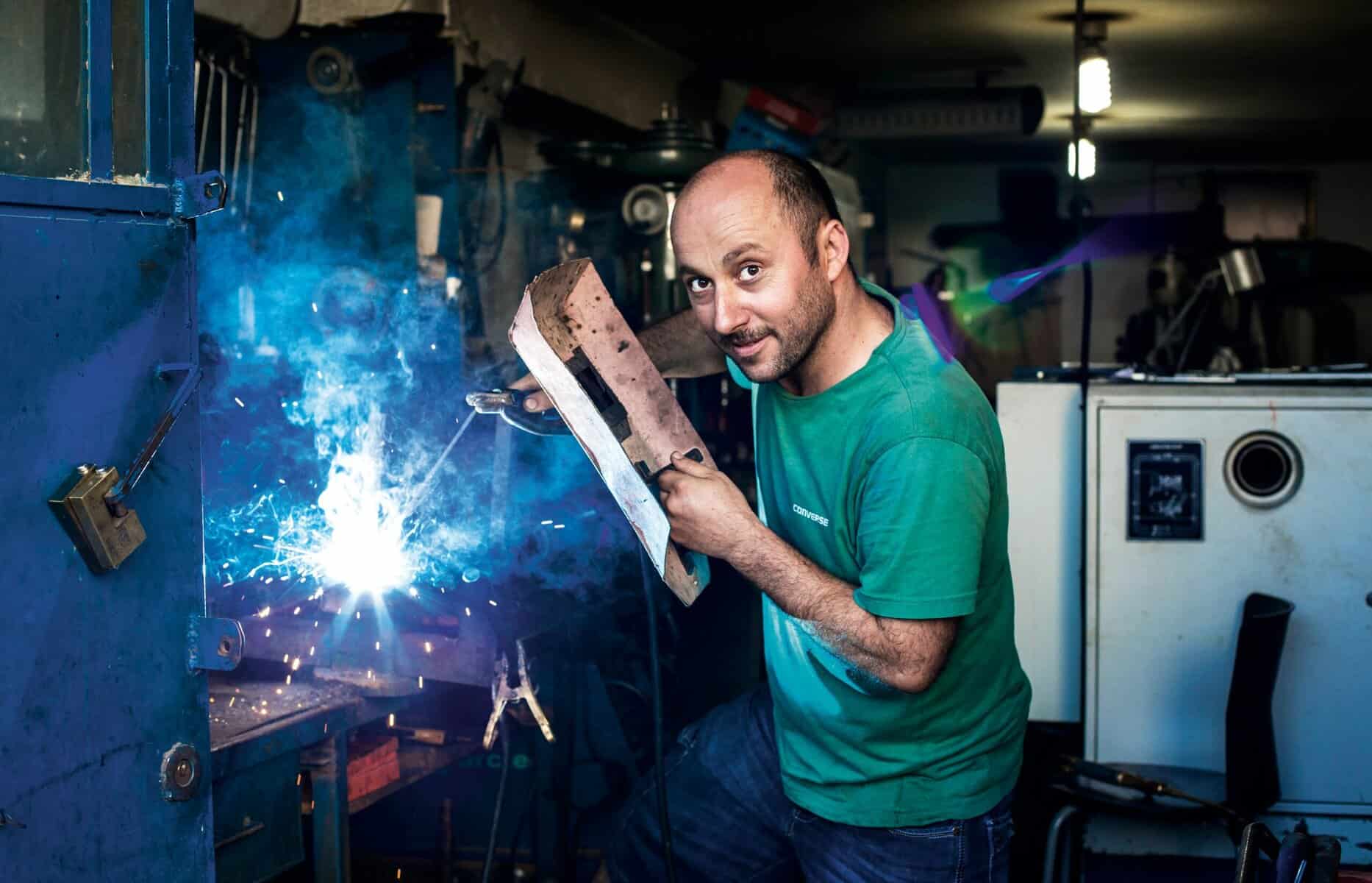 main holding welding mask with blue spark