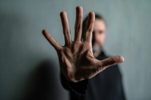 spread out hand signaling stop with blurred man in background